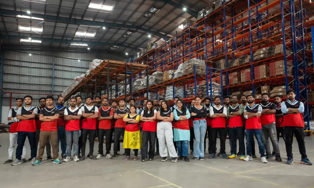 AAJ SCM team standing together inside warehouse - local hiring